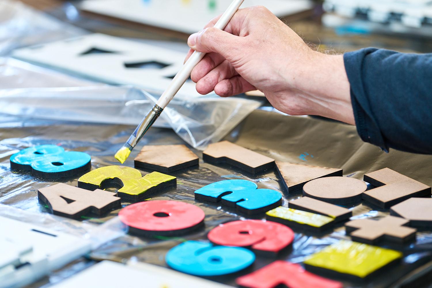 A volunteer painting colourful educational materials