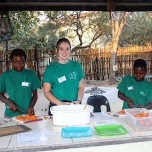 DAKTARI's volunteer and children preparing food for the animals