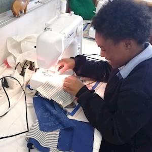 High school boys and girls from Masi High attend weekly lessons in sewing in our High School Sewing Programme, held in partnership with The Sewing Café, at Chasmay Road Campus.
The objective of this project is to upskill youth through skills development training – learning how to sew. This skill can be used as a means of employment, or to inspire these young people to follow a career in fashion or design.