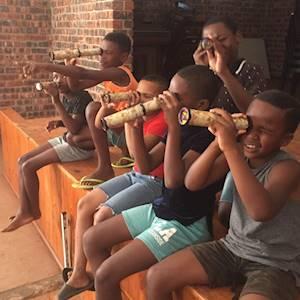 Afterschool enrichment programme children using a kaleidoscope for the first time, and learning about patterns and colors.