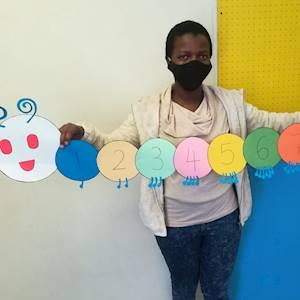 Proud student with the handmade educational aid she designed and made during her training module - Numeracy